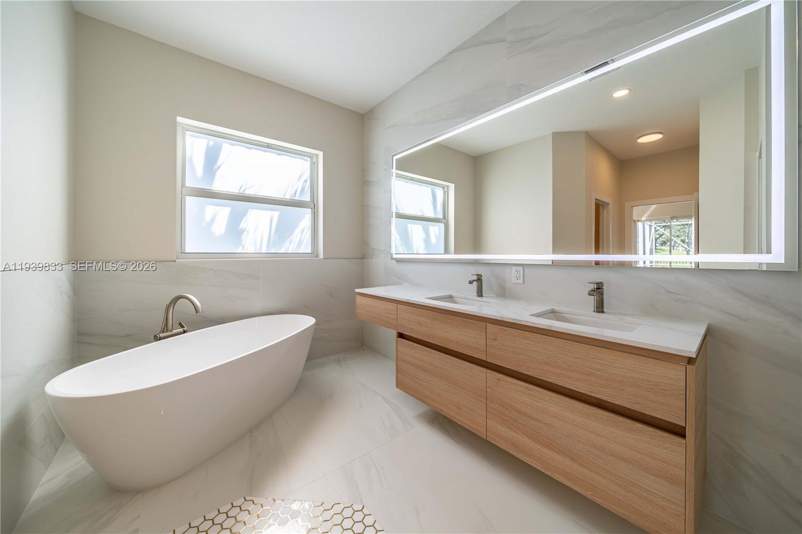 8041 Bermuda Point Lane Davie, FL 33328 - Photo 42 of 60 a bathroom with a large tub a sink and a window