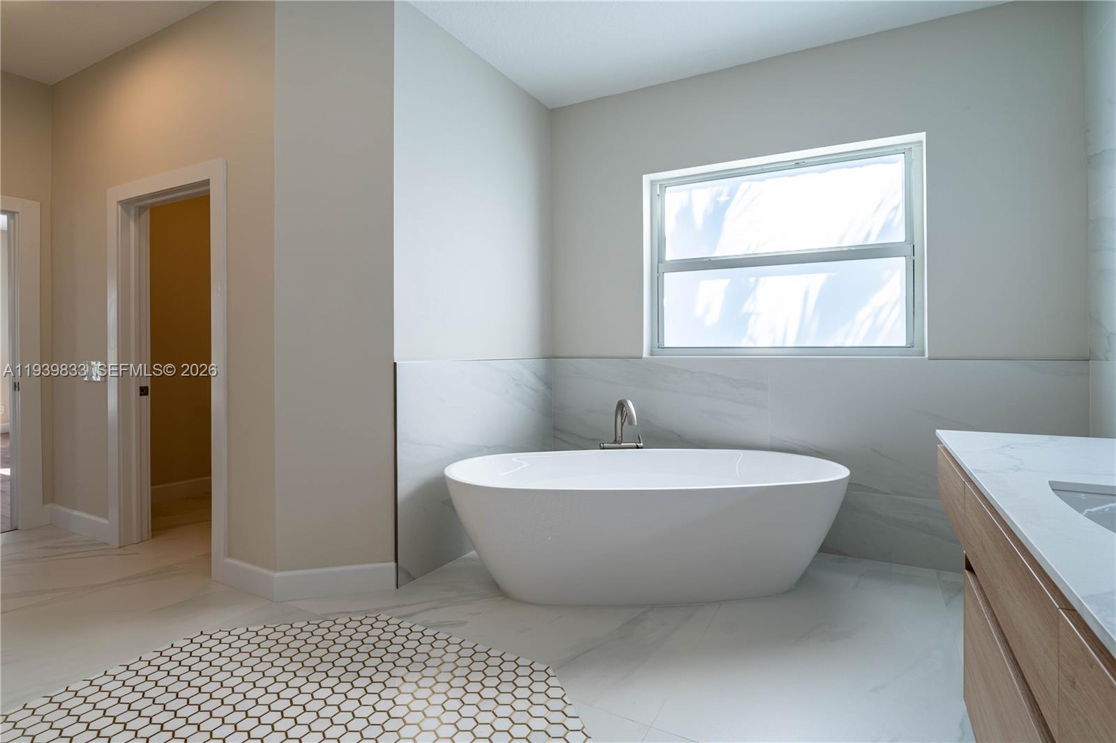 8041 Bermuda Point Lane Davie, FL 33328 - Photo 43 of 60 a spacious bathroom with a bathtub and window