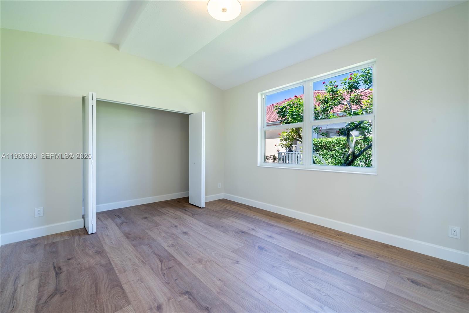 8041 Bermuda Point Lane Davie, FL 33328 - Photo 45 of 60 an empty room with wooden floor window and hallway