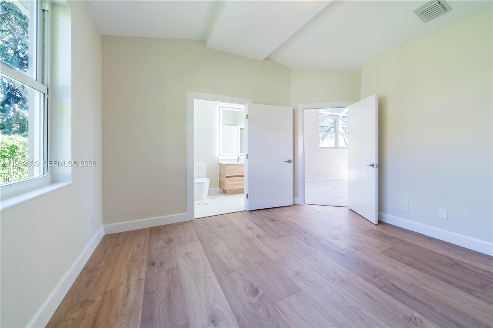 8041 Bermuda Point Lane Davie, FL 33328 - Photo 46 of 60 a view of an empty room with wooden floor and window