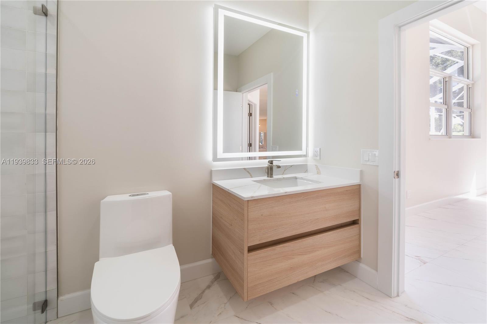 8041 Bermuda Point Lane Davie, FL 33328 - Photo 47 of 60 a bathroom with a toilet sink and mirror