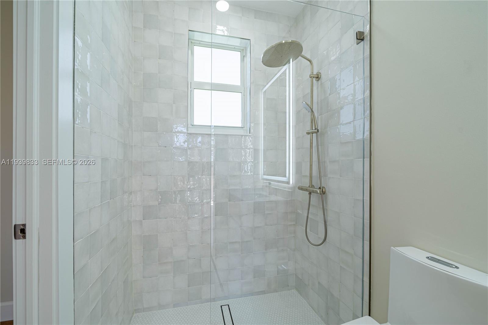 8041 Bermuda Point Lane Davie, FL 33328 - Photo 48 of 60 a bathroom with a glass shower door