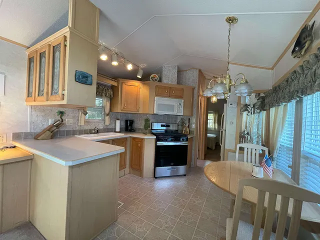 a kitchen with kitchen island granite countertop a sink a counter top space and stainless steel appliances