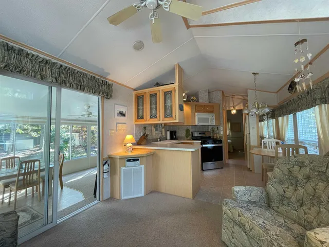 a living room with couches and kitchen view with wooden floor