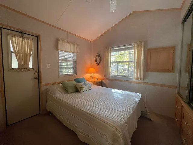 a bedroom with a bed and a dresser next to a window