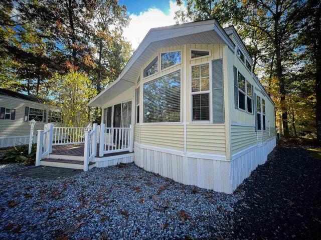 a view of a house with a yard and large tree