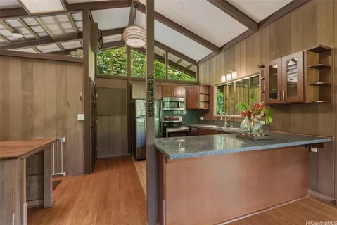 a kitchen with stainless steel appliances granite countertop a sink and a wooden cabinets