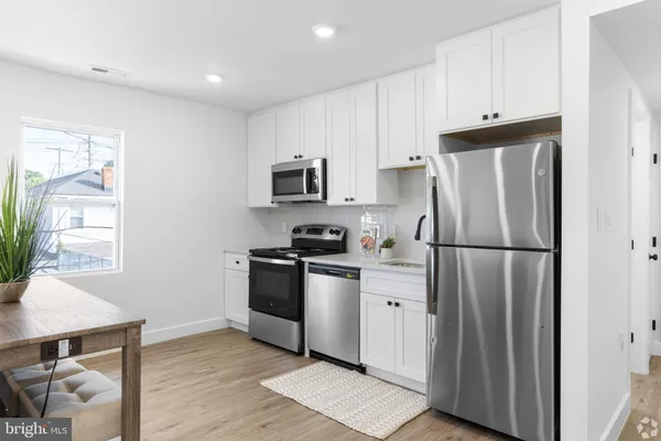 a kitchen with stainless steel appliances a refrigerator a stove a sink a counter space and cabinets