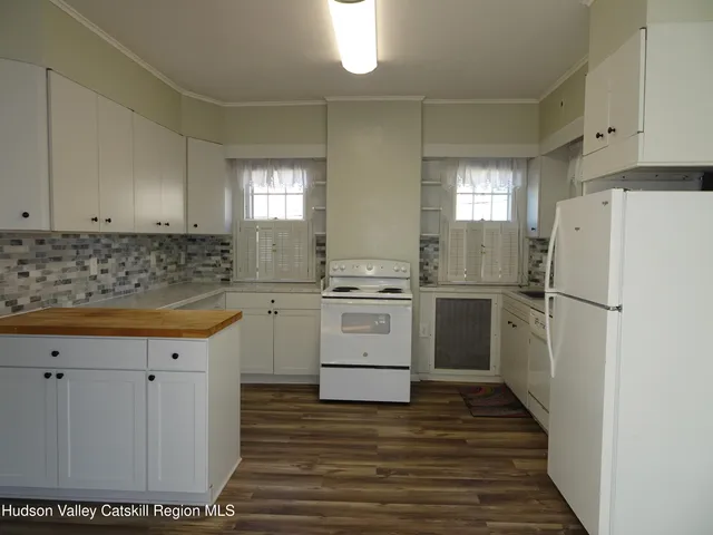 a kitchen with a white stove refrigerator and cabinets