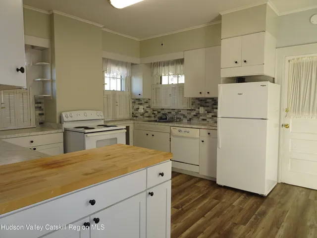 a kitchen with white cabinets and white appliances