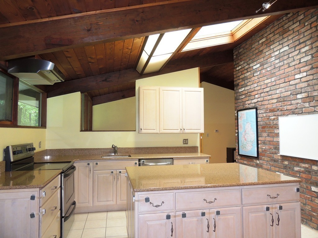 76 Wolf Rock Road Carlisle, MA 01741 - Photo 2 of 20 a kitchen with granite countertop a sink a stove and cabinets