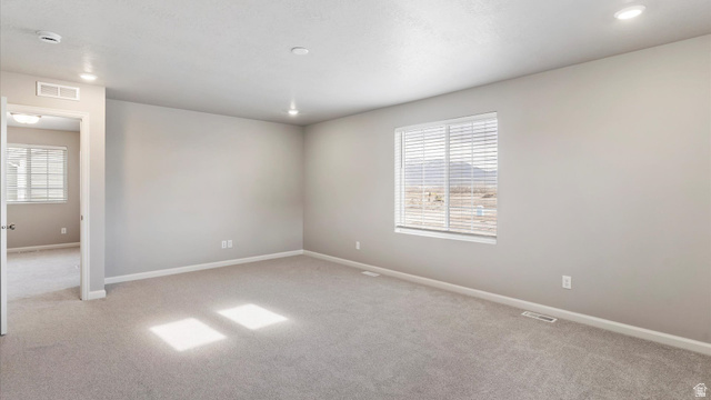 82 Provo River Road, Unit 251 Saratoga Springs, UT 84045 - Photo 17 of 32 Spacious room featuring neutral carpeting, light gray wall paint, a large window with horizontal blinds, overhead recessed lighting, and white baseboards