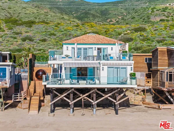 a kitchen with stainless steel appliances granite countertop a sink a stove a refrigerator and island with wooden floor