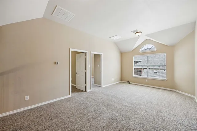 an empty room with windows and a ceiling fan