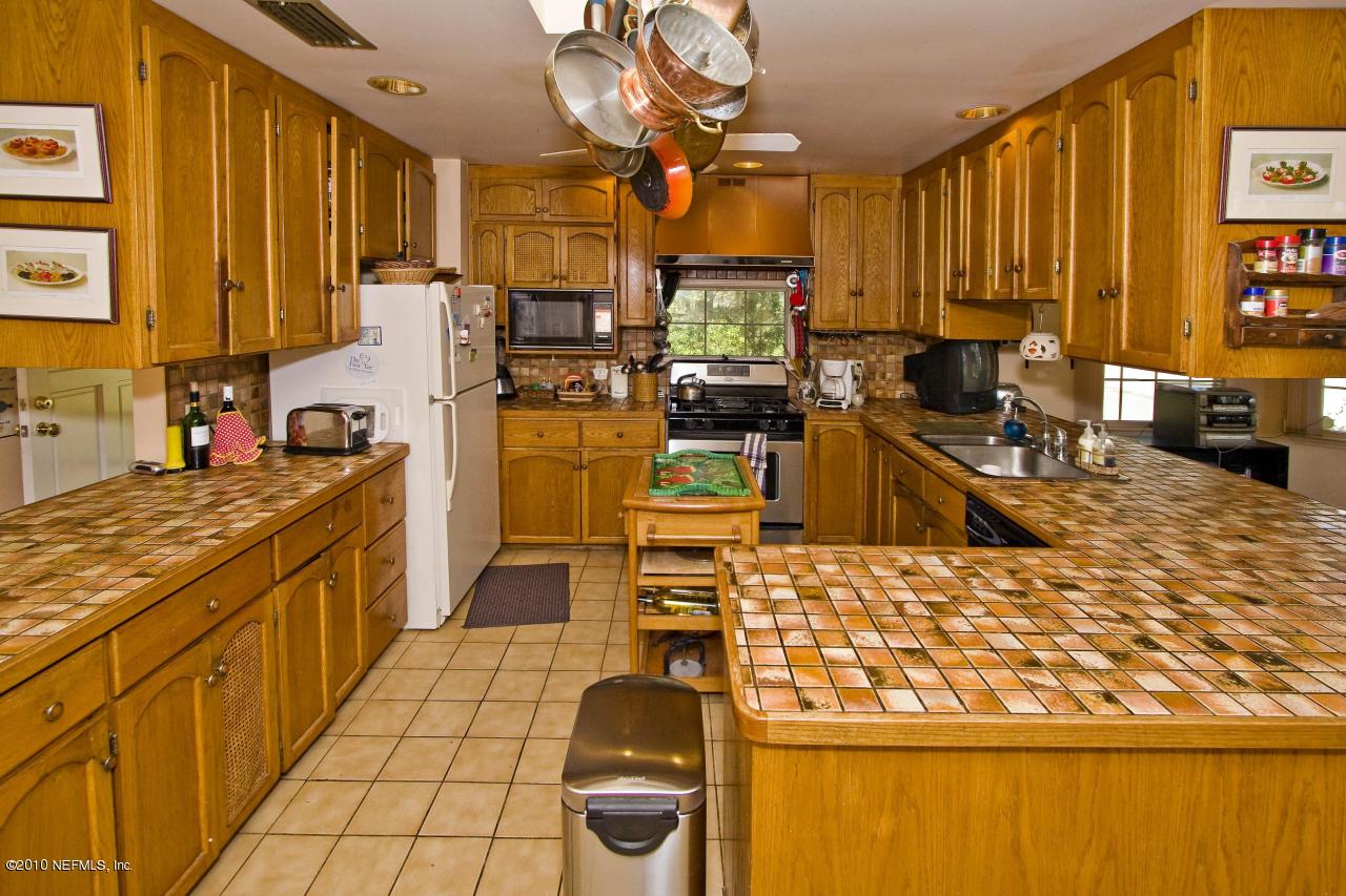 84 Water Street St. Augustine, FL 32084 - Photo 12 of 25 a kitchen with stainless steel appliances kitchen island granite countertop a stove top oven a sink dishwasher and cabinets with wooden floor