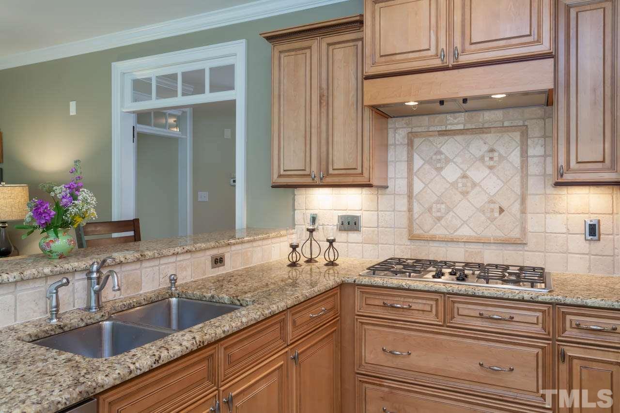 8814 Fidelis Lane Raleigh, NC 27613 - Photo 9 of 25 A closer view of the Breakfast bar, gas cooktop and gorgeous cabinetry.