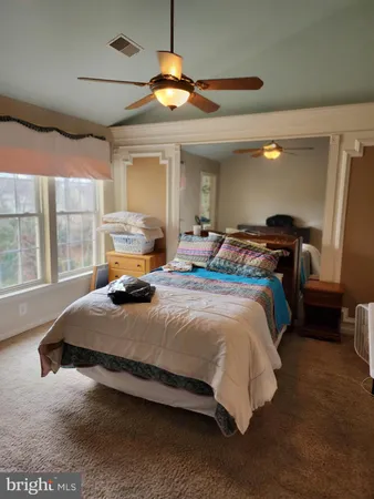 a bedroom with a bed window and dresser