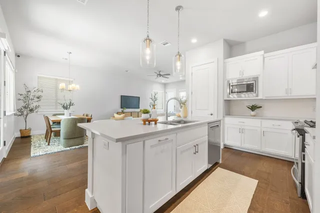 a kitchen with a sink a stove a refrigerator and white cabinets