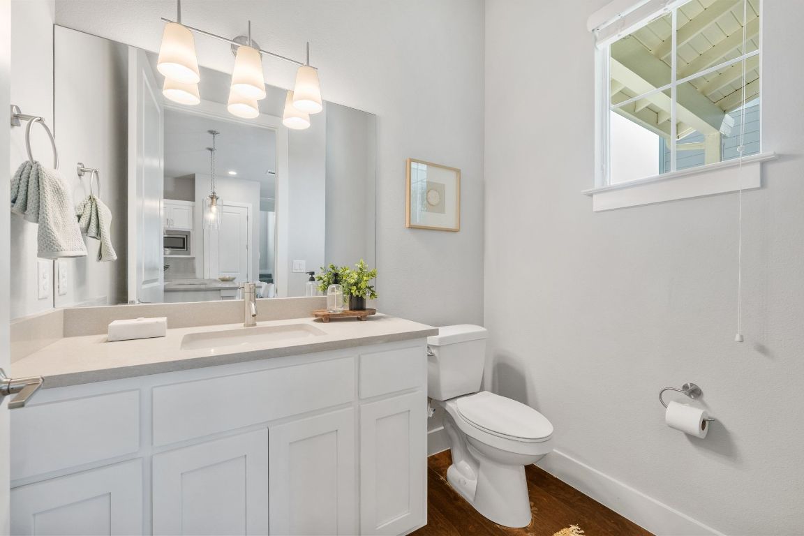 11112 Zimmerman Lane, Unit 24 Austin, TX 78726 - Photo 11 of 29 a bathroom with a toilet a sink a mirror a window and vanity