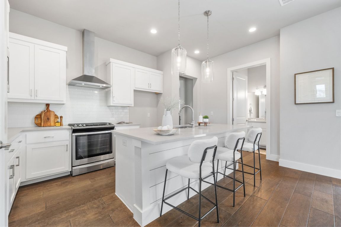 11112 Zimmerman Lane, Unit 24 Austin, TX 78726 - Photo 2 of 29 a kitchen with kitchen island a stove a table and chairs in it
