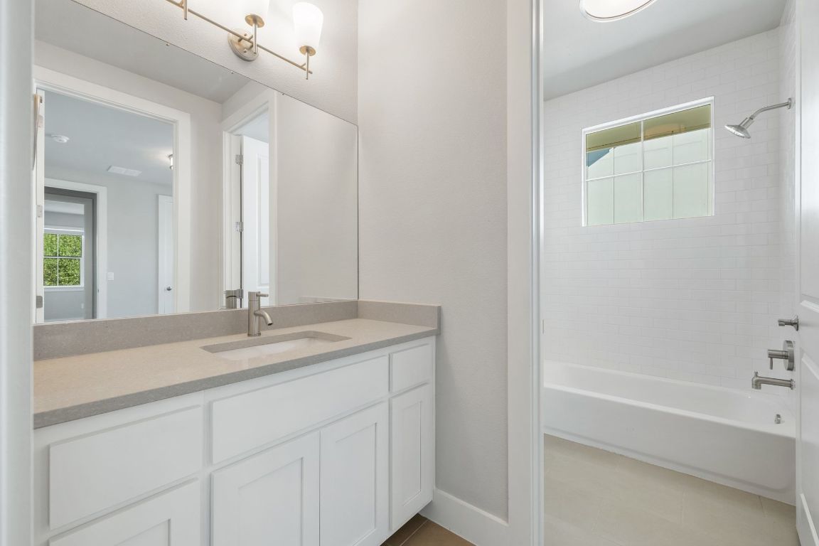 11112 Zimmerman Lane, Unit 24 Austin, TX 78726 - Photo 22 of 29 a bathroom with a granite countertop sink and a mirror