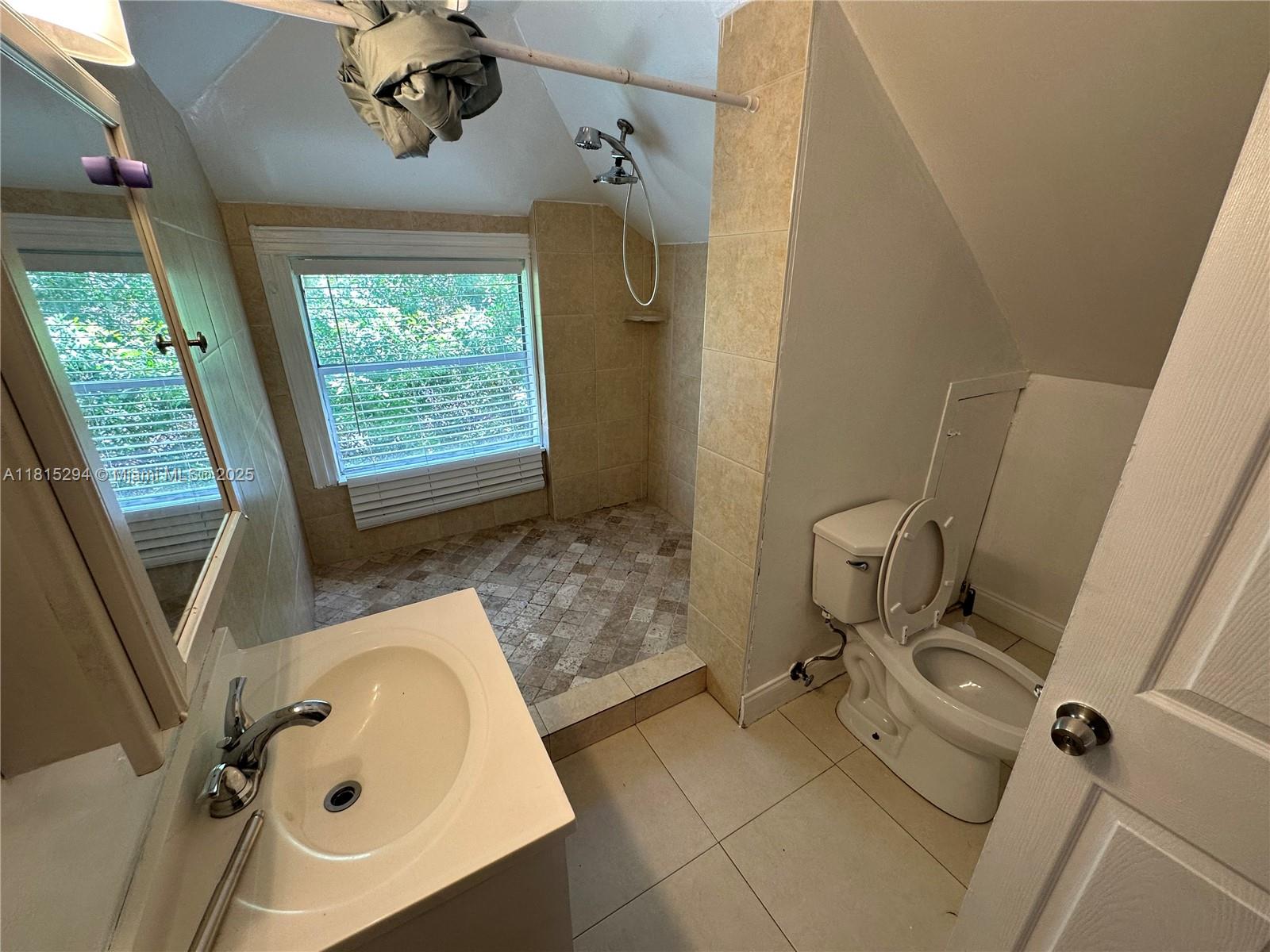 213 Stirling Road Dania Beach, FL 33004 - Photo 2 of 12 a bathroom with a sink a toilet and shower