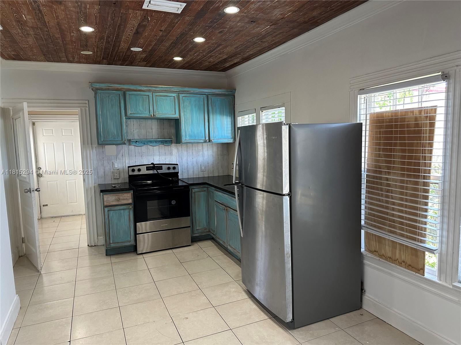 213 Stirling Road Dania Beach, FL 33004 - Photo 3 of 12 a kitchen with granite countertop a refrigerator and a sink