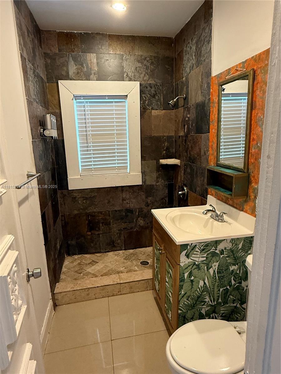 213 Stirling Road Dania Beach, FL 33004 - Photo 5 of 12 a bathroom with a sink a toilet and a bathtub