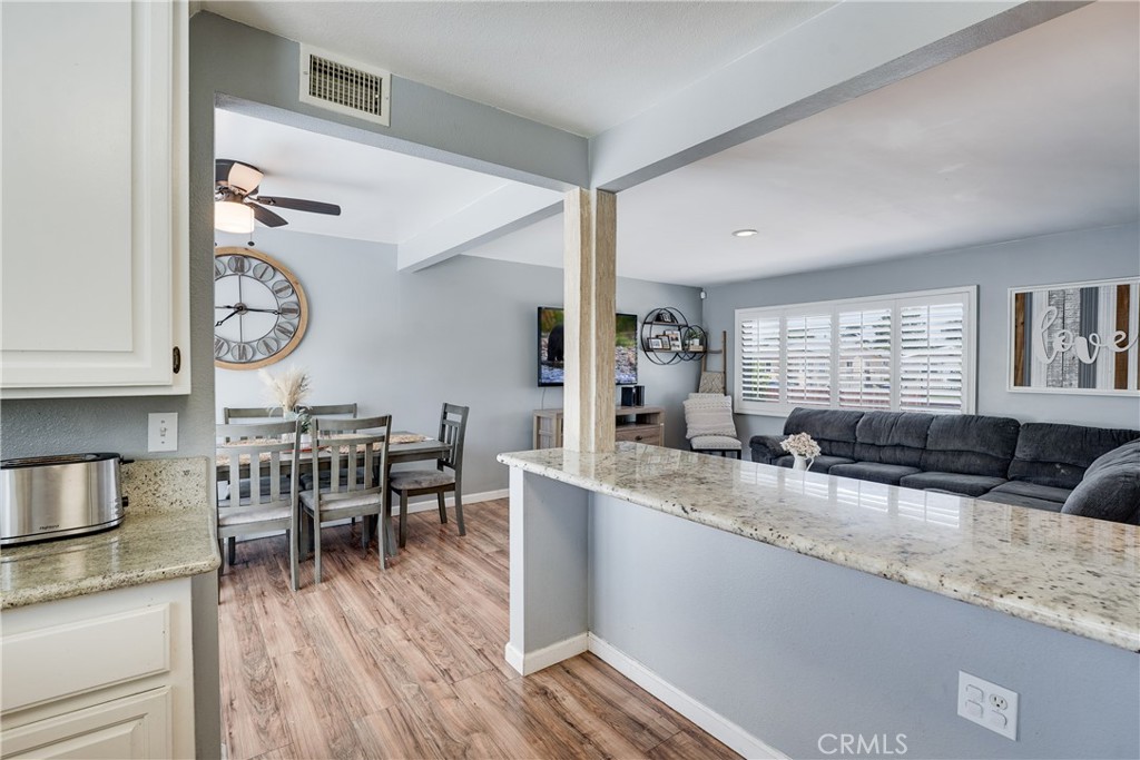 5734 Mountain View Avenue Riverside, CA 92504 - Photo 12 of 28 a very nice looking kitchen with granite countertop a stove a sink a dining table and chairs with wooden floor