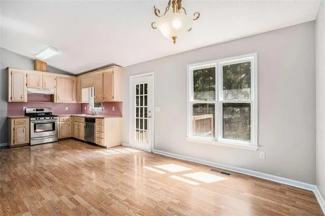 a kitchen with stainless steel appliances granite countertop a stove a sink and a refrigerator