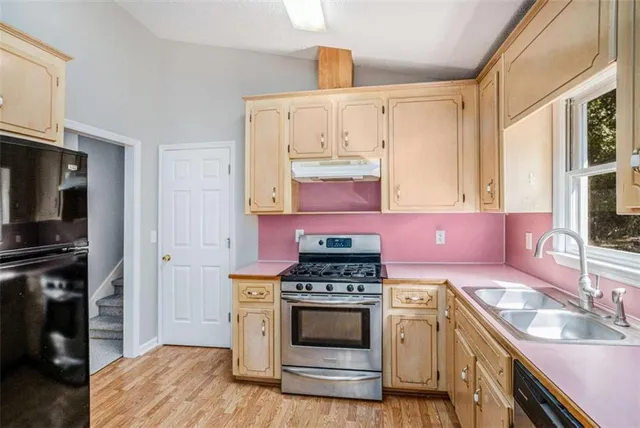 a kitchen with stainless steel appliances a stove a sink and a microwave