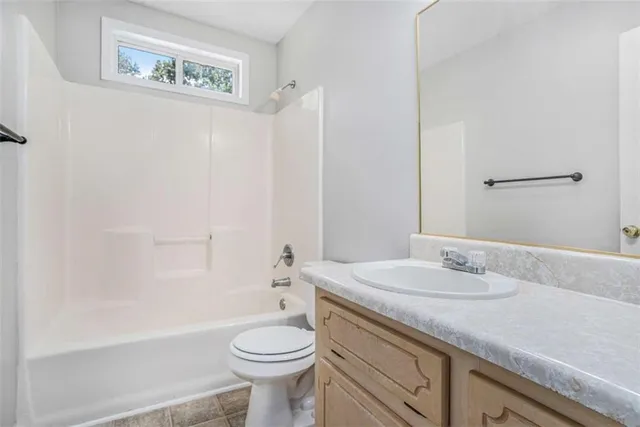 a bathroom with a granite countertop sink a toilet and bathtub