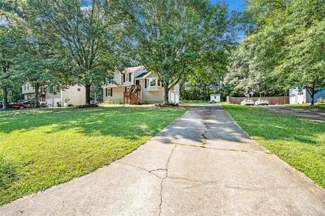 a front view of a house with a yard and trees