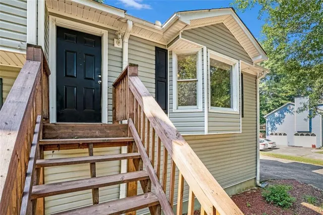 a view of a house with entryway and wooden fence