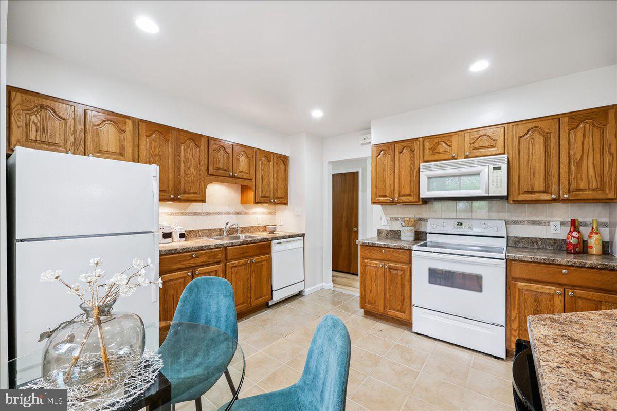 1901 Ladd Street Silver Spring, MD 20902 - Photo 28 of 101 a kitchen with stainless steel appliances granite countertop a refrigerator a stove top oven a sink dishwasher and white cabinets with wooden floor