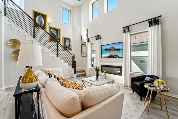 a living room with furniture kitchen view and a chandelier