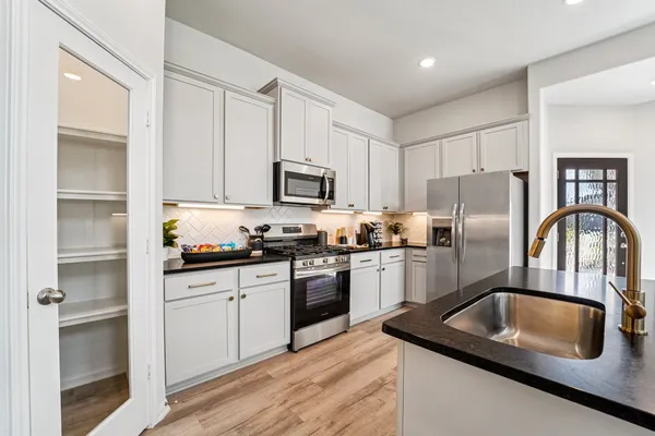 a kitchen with kitchen island granite countertop stainless steel appliances and wooden cabinets