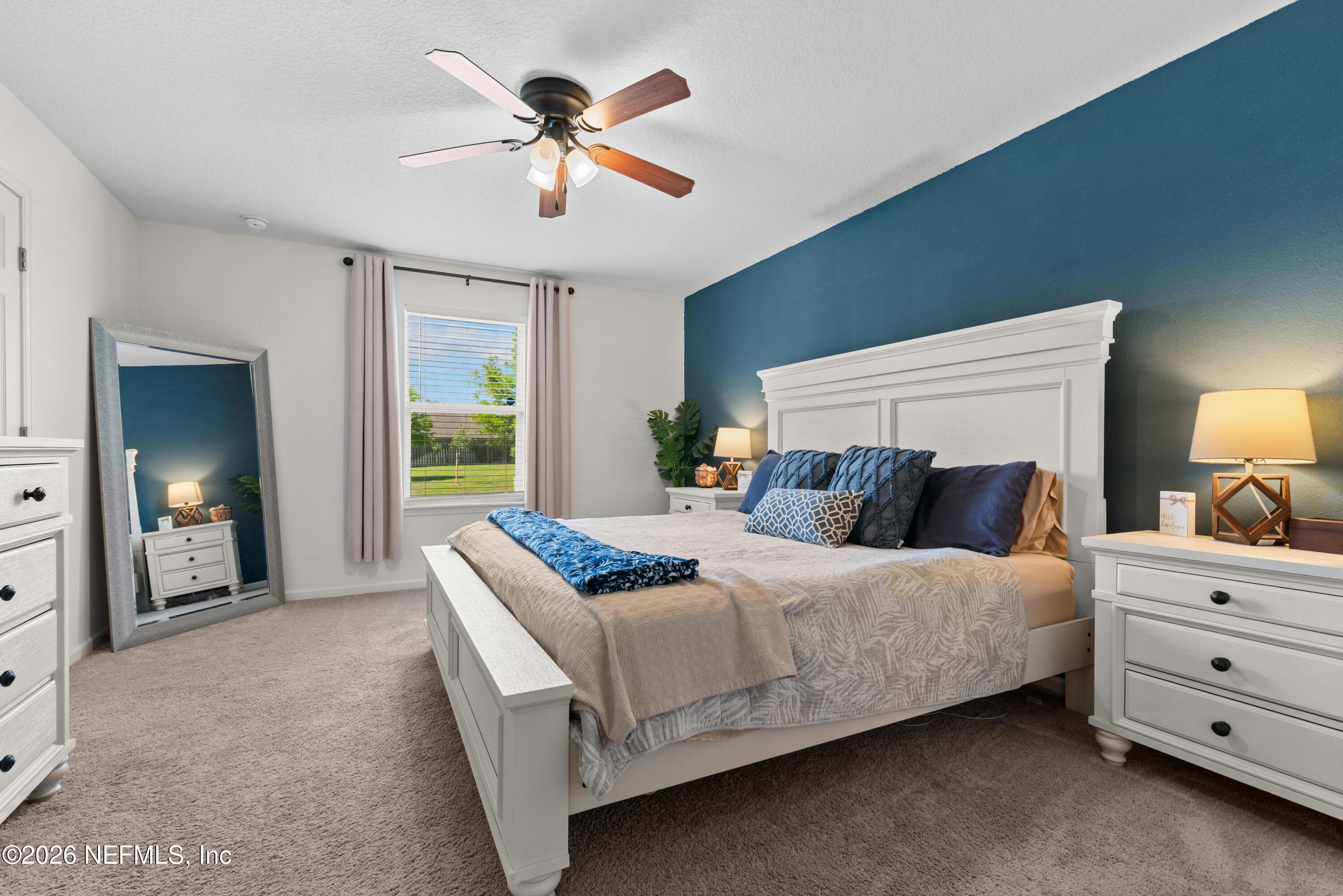 6178 Daylilly Road Macclenny, FL 32063 - Photo 15 of 29 a bedroom with a bed and a chandelier