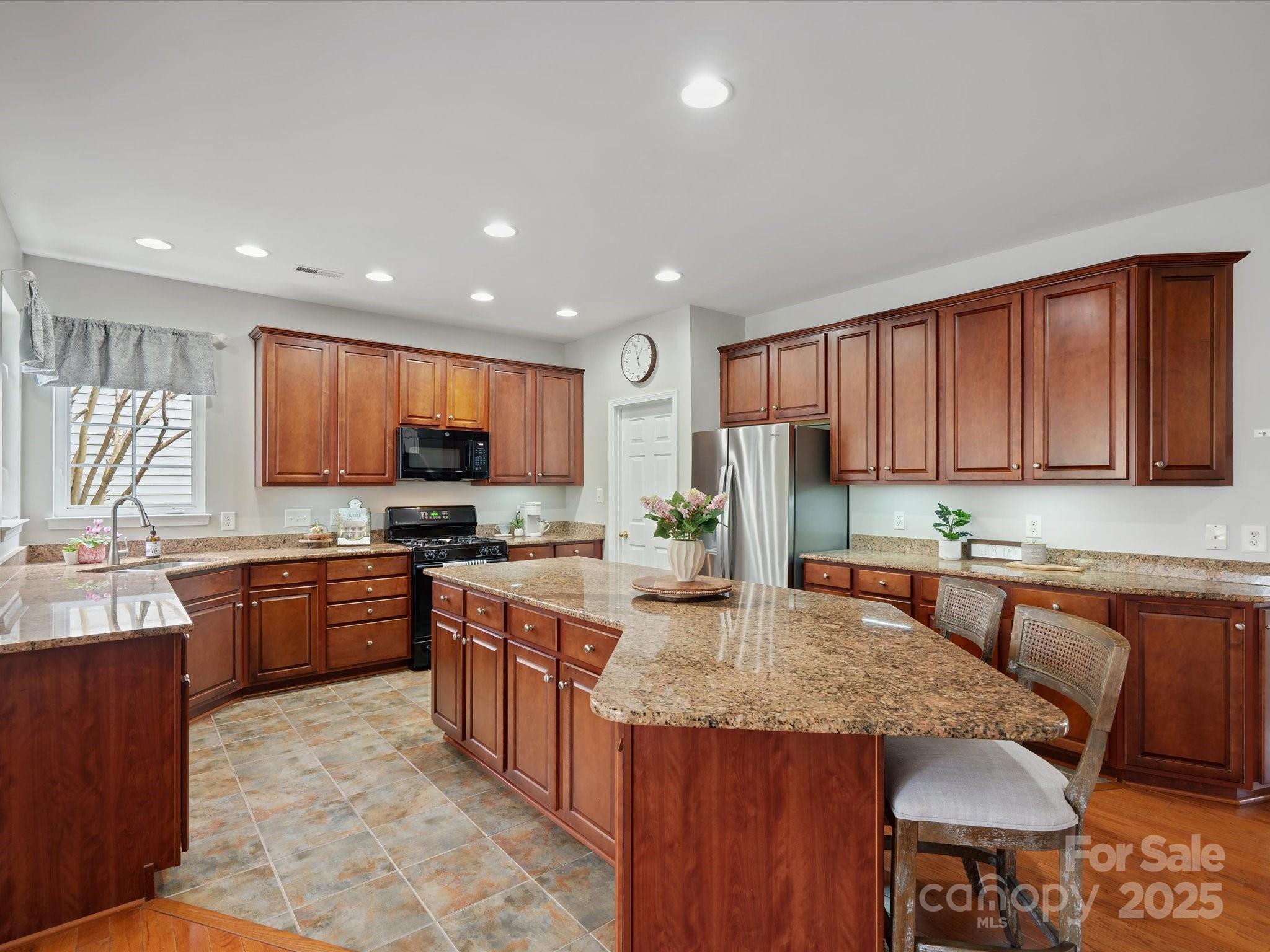 809 Circle Trace Road Monroe, NC 28110 - Photo 22 of 47 a kitchen with stainless steel appliances granite countertop a stove top oven a sink dishwasher and a refrigerator with wooden cabinets