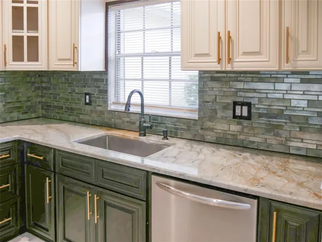 a kitchen with granite countertop a sink and cabinets