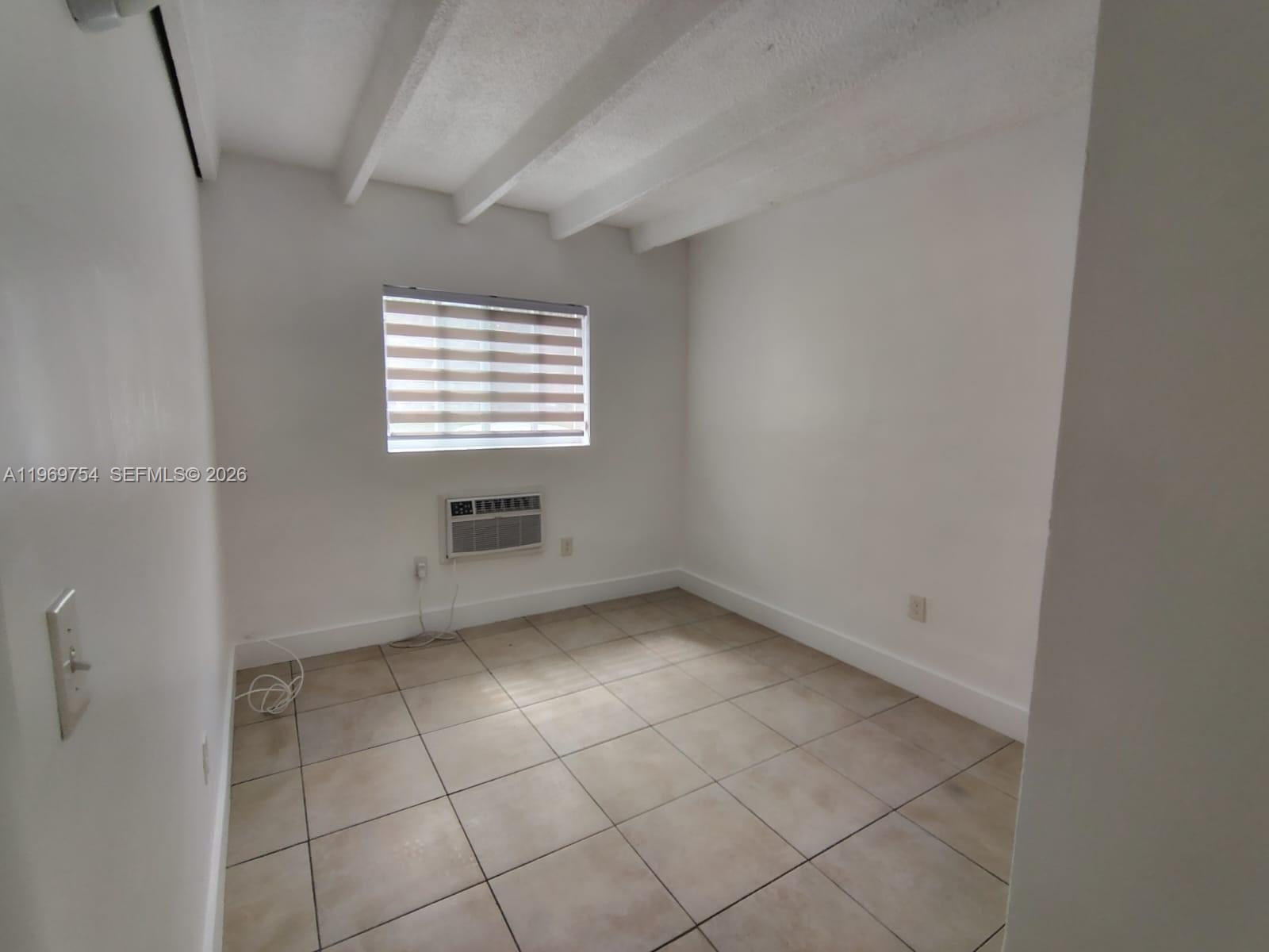 741 Northwest 60th Street, Unit 3 Miami, FL 33127 - Photo 9 of 15 an empty room with a window