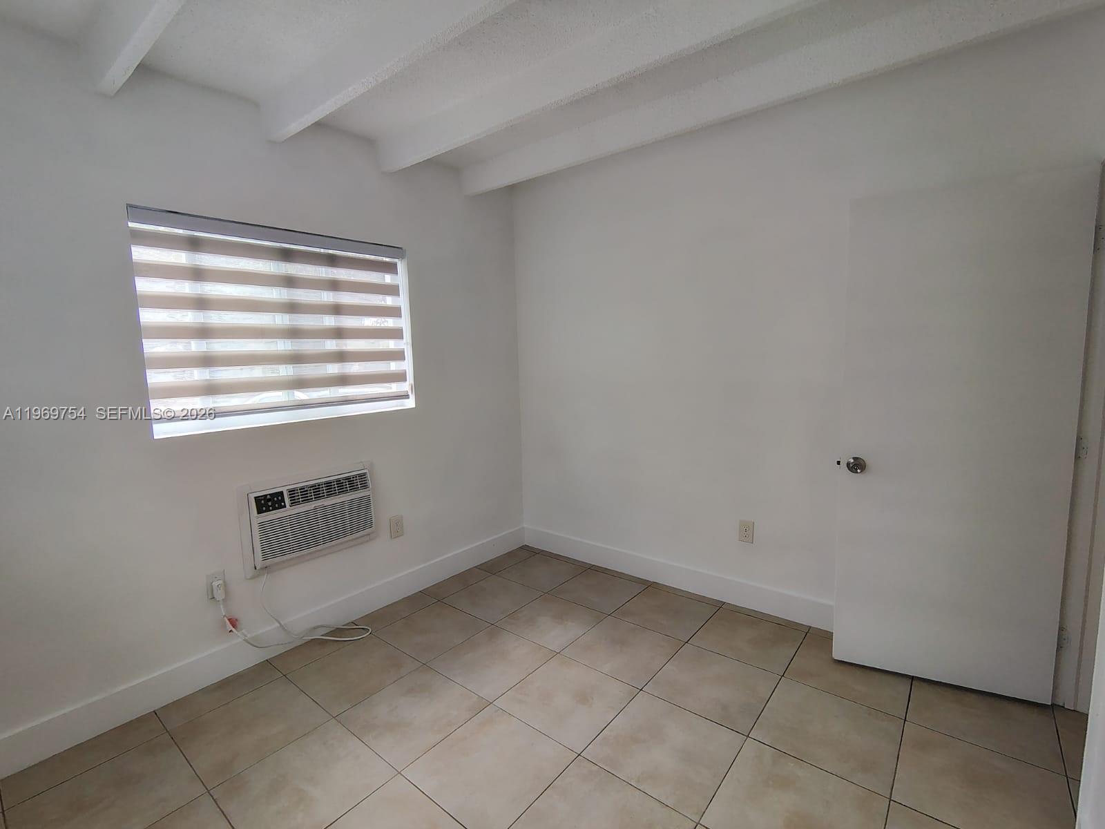 741 Northwest 60th Street, Unit 3 Miami, FL 33127 - Photo 10 of 15 an empty room with a empty space and window