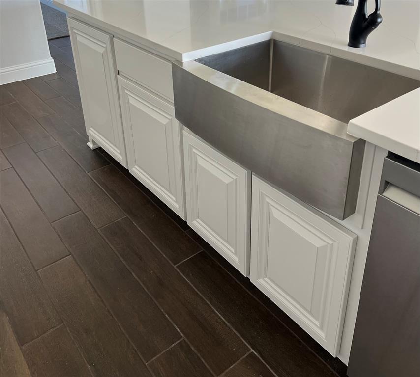 2108 Charters Circle Nevada, TX 75173 - Photo 10 of 37 Kitchen view of wood tiled floors, stainless steel dishwasher, and white cabinets