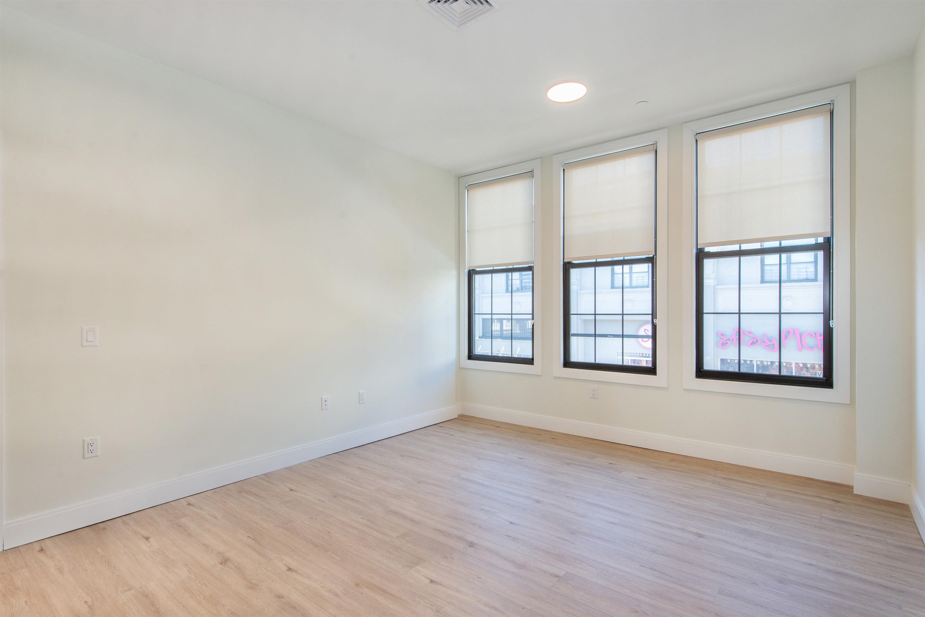 3510 Bergenline Avenue, Unit 205 Union City, NJ 07087 - Photo 6 of 21 an empty room with wooden floor and windows