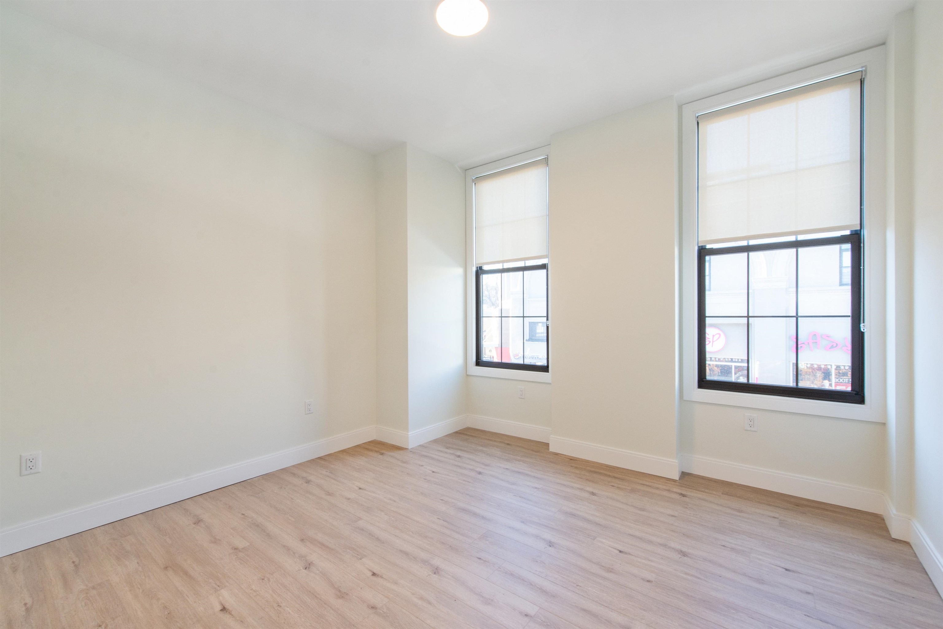3510 Bergenline Avenue, Unit 205 Union City, NJ 07087 - Photo 7 of 21 an empty room with wooden floor and windows