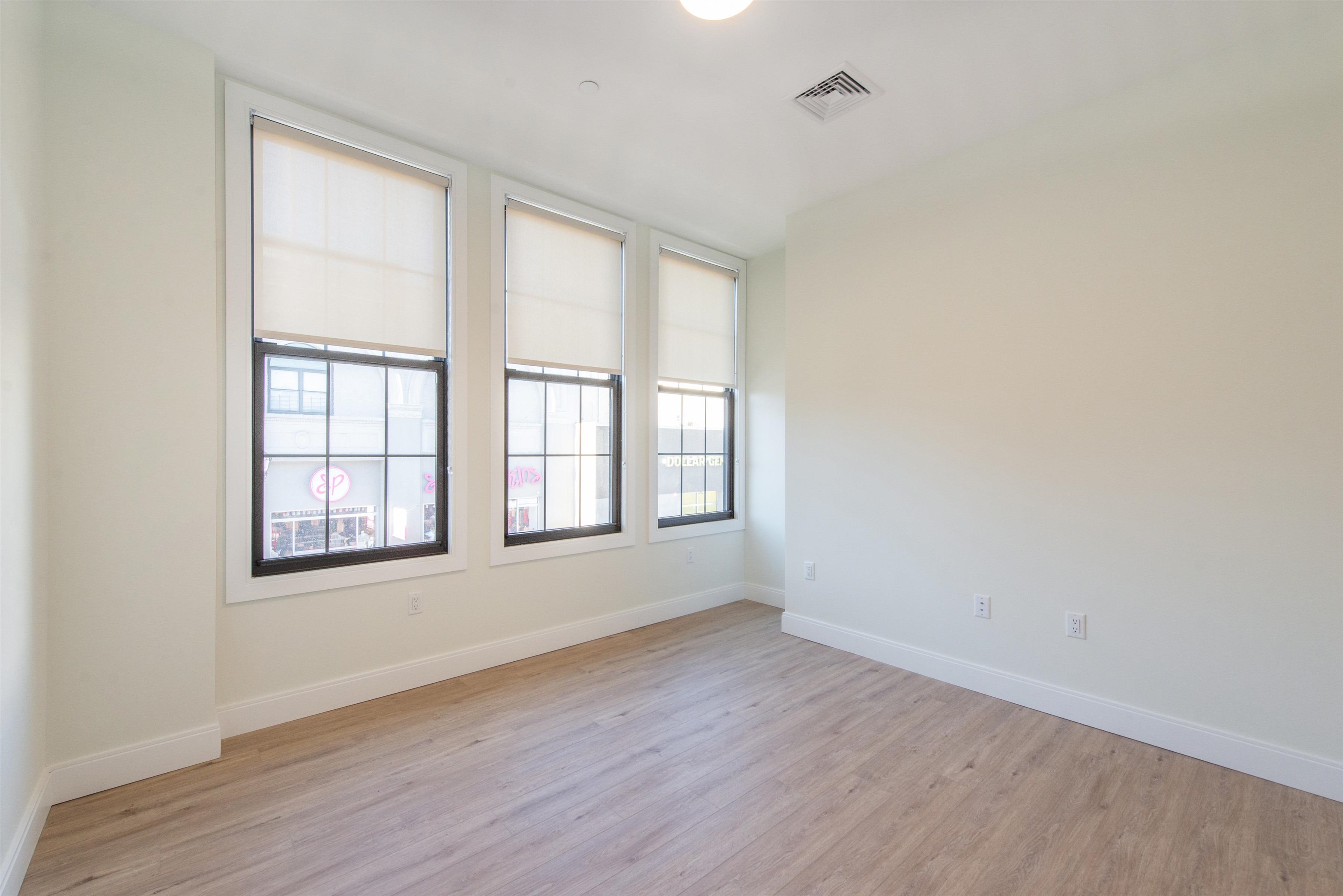 3510 Bergenline Avenue, Unit 205 Union City, NJ 07087 - Photo 8 of 21 an empty room with wooden floor and windows