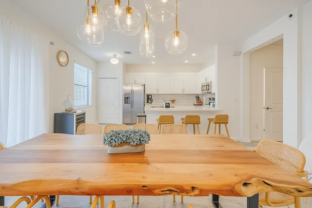 a large white kitchen with kitchen island a stove a sink dishwasher and white cabinets with wooden floor