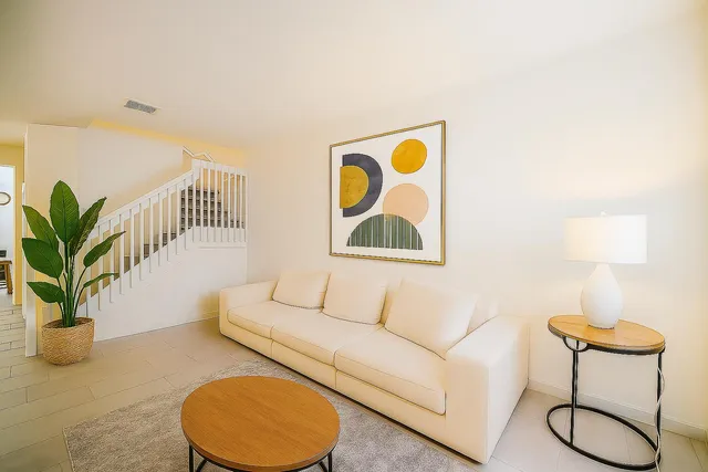 a living room with furniture and a potted plant