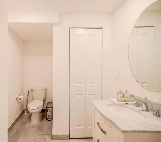 a bathroom with a granite countertop sink a toilet and a mirror