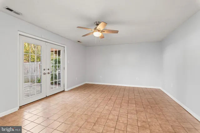 an empty room with windows and ceiling fan